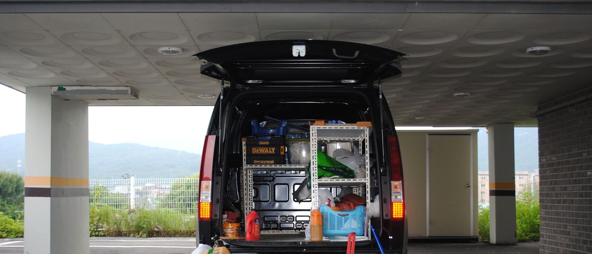 Offenes Heck eines Transporters mit Regaleinbau, Werkzeugkoffern und Material für den nächsten Einsatz.